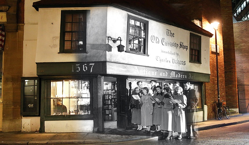 Các sinh viên trường Cao đẳng King London hát mừng giáng sinh bên ngoài cửa hiệu Old Curiosity trên phố Portsmouth, ngày 12/12/1956. 