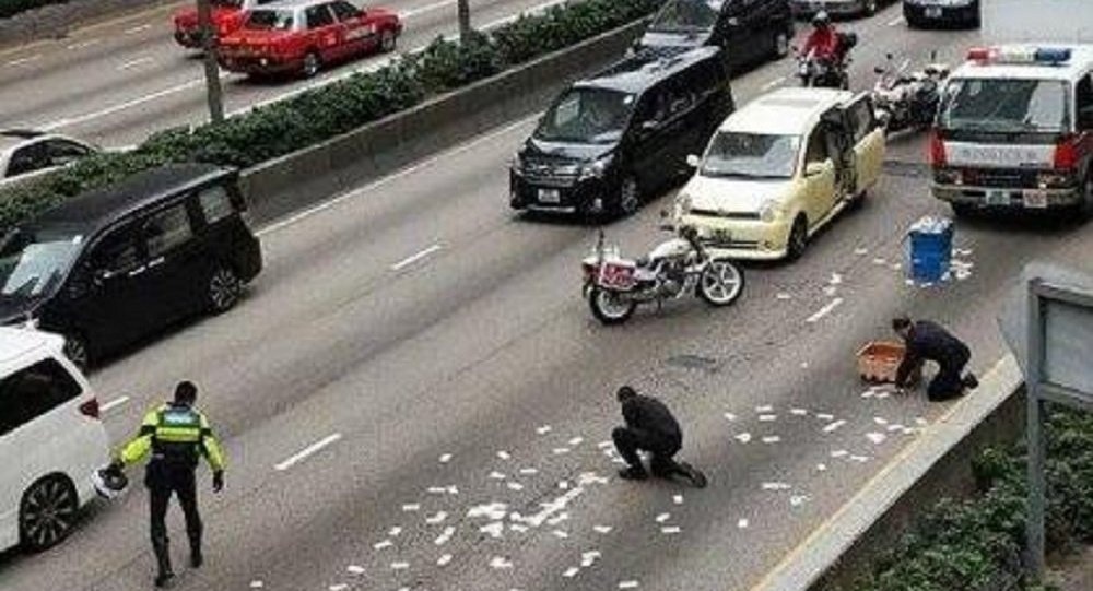 Người dân nhặt tiền bất chấp giao thông đông đúc. Ảnh: Telegraph