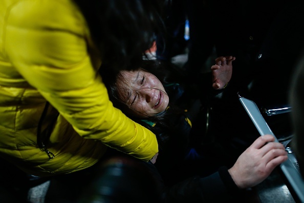 Một người phụ nữ khóc ngất khi chờ tin người thân đang điều trị ở bệnh viện. Chính quyền Thượng Hải đã thành lập nhóm điều tra nguyên nhân sự việc. Ảnh: AFP