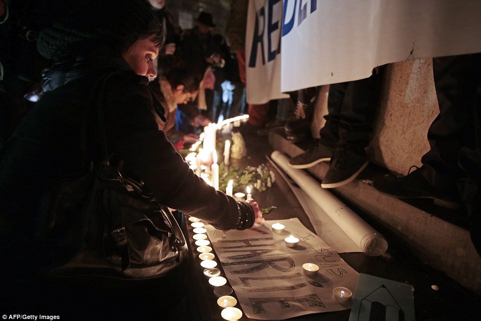  Một người phụ nữ thắp nến tại quảng trường Republique ở Paris vào đêm 7/1.