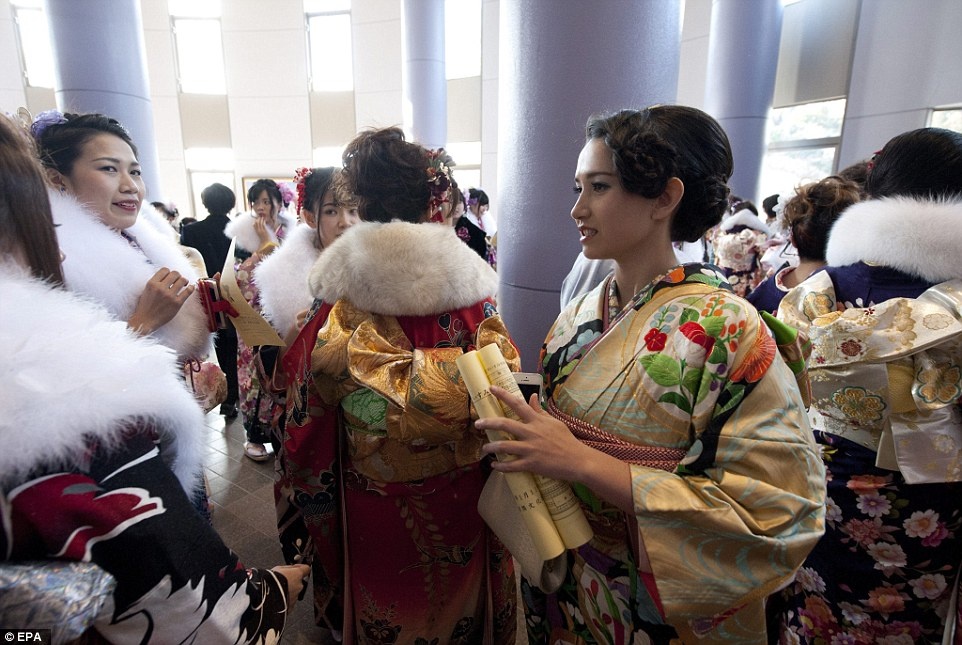 Cô Anne Nakajima (phải), 20 tuổi, trò chuyện cùng bạn bè dự lễ trưởng thành ở thành phố Isumi, tỉnh Chiba. Để xuất hiện lộng lẫy nhất trong ngày lễ trưởng thành, các cô gái phải đặt lịch hẹn trước cả năm với những cơ sở trang điểm, làm tóc và đặt thuê (hoặc mua) kimono vừa vặn mới mình nhất.