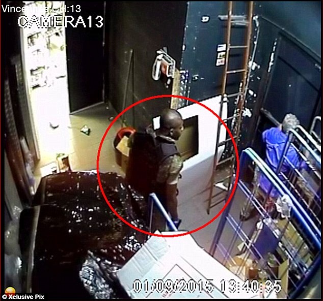 Amedy Coulibaly cầm súng, uy hiếp 1 nhân viên cửa hàng. Ảnh: Xclusive Pix