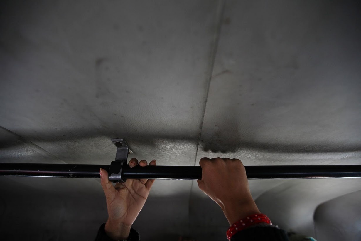 Hai phụ nữ nắm thanh ngang khi đi xe buýt dành cho nữ giới. 