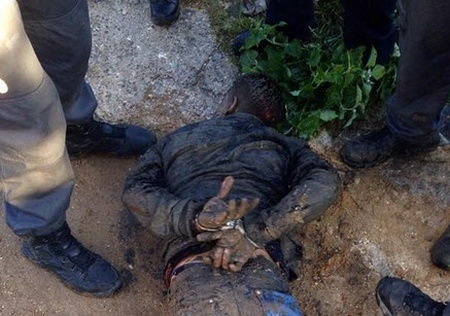 Nghi can bị cảnh sát khống chế. Ảnh: Twitter/RT