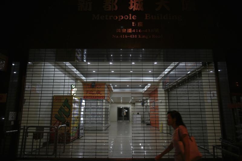 Một phụ nữ đi ngang một căn chung cư của người dân tầng lớp trung lưu ở Hong Kong. Bên trong chung cư, rất nhiều chủ nhà luôn muốn 