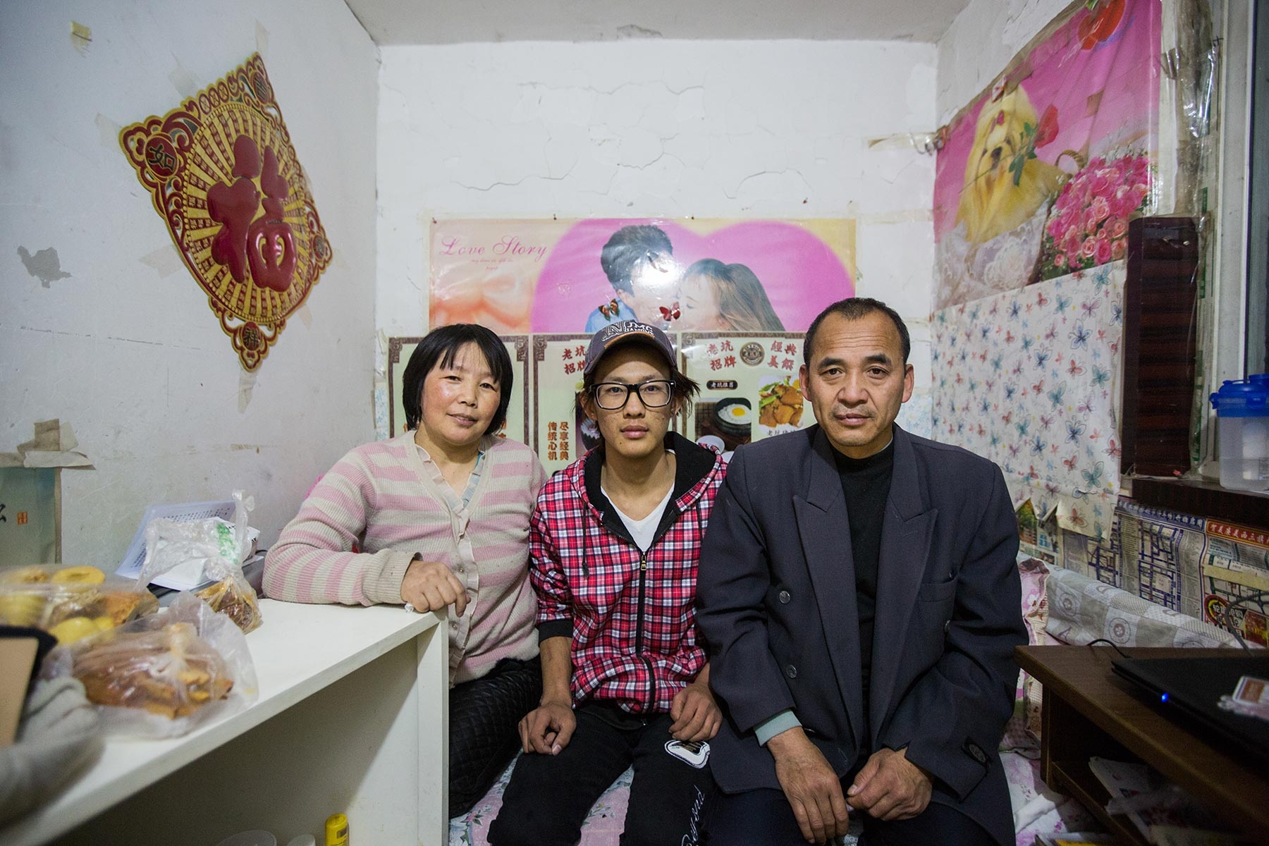 Xu Junping, 46 tuổi, rời vùng quê Sơn Tây để tới Bắc Kinh cách đây 8 năm. Bà sống cùng con trai Zhou Zhengdi, 17 tuổi, trong căn phòng dưới lòng đất. Chồng của Xu, ông Zhou Hailin, 48 tuổi, là một nhân viên bảo vệ, làm việc và sinh sống tại một nhà tắm công cộng ở Bắc Kinh. Thirng thoảng ông Zhou tới thăm hai mẹ con. Những lúc đó, cả ba người sẽ cùng ngủ trên một chiếc giường chật hẹp.   “Chúng tôi phải khúm núm khi ngủ. Chân người này sẽ chạm vào mặt người kia. Đó là cách duy nhất. Nếu cả ba đều quay đầu về một phía, điều đó là không thể. Thật may mắn là chúng tôi không béo”.