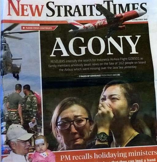 Tờ New Straits Times của Malaysia đưa tin về tai nạn của chuyến bay QZ8501, cùng hình ảnh người thân của những hành khách trên chuyến bay QZ8501 khóc ngất khi nghe tin dữ. Ảnh: AFP
