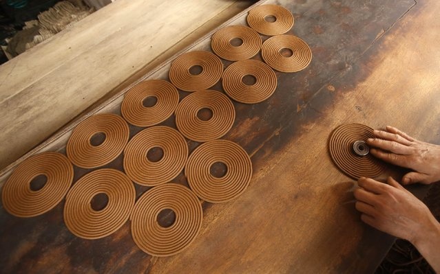Công nhân tại làng Hong Chau đang xếp các vòng nhang. Bên cạnh sử dụng các cây nhang, nhiều người chuộng sử dụng hương vòng, cắm bằng cây trụ trên bát hương với ý nghĩa tượng trưng cho trục vũ trụ.