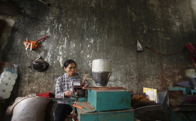 Một phụ nữ đang chuẩn bị các bó nhang để sẵn sàng đem bán vào những ngày giáp Tết. Bàn thờ ngày Tết của mỗi gia đình Việt không thể thiếu nén hương, bên cạnh mâm ngũ quả và những bó hoa cúng. Người Việt khi thắp nhang thường chọn số lẻ (1, 3 hoặc 5 nén nhang) với ý nghĩa số lẻ mang tính âm.