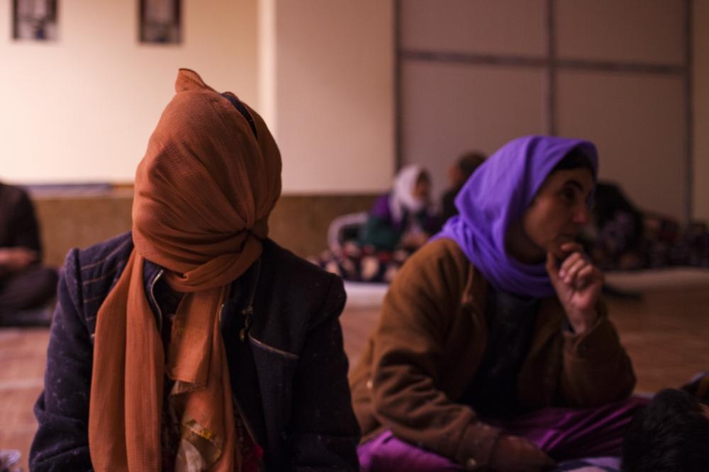 Người phụ nữ này không thể nhớ tên của chính mình. Bà trùm kín khăn lên mặt và đợi người thân. 