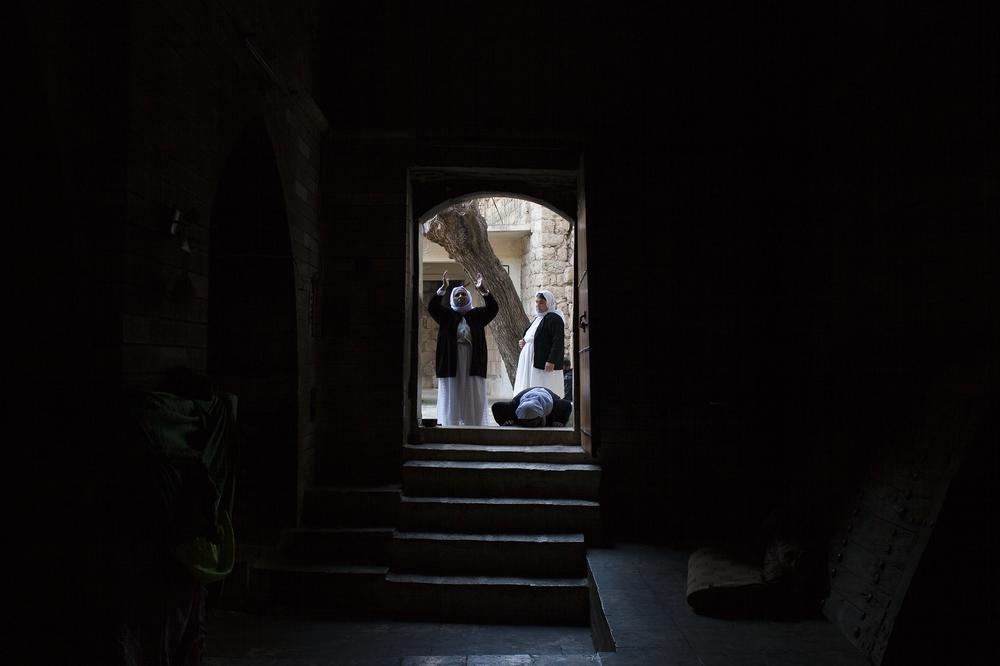 Hai người đàn ông cầu nguyện trước cửa đền thờ thánh thần của người Yazidis tại Lalish.