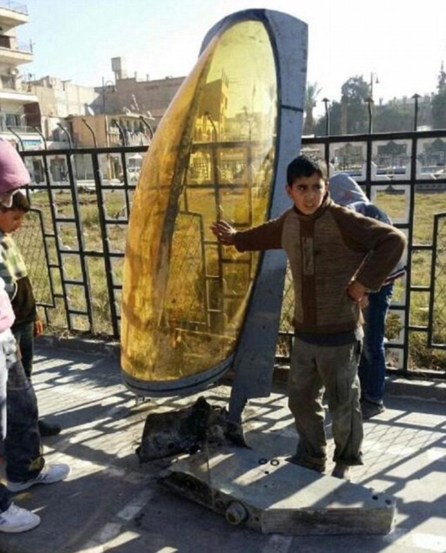 Phiến quân IS trưng bày một phần trong xác máy bay của Jordan mà họ tuyên bố bắn rơi. Ảnh: Daily Mail