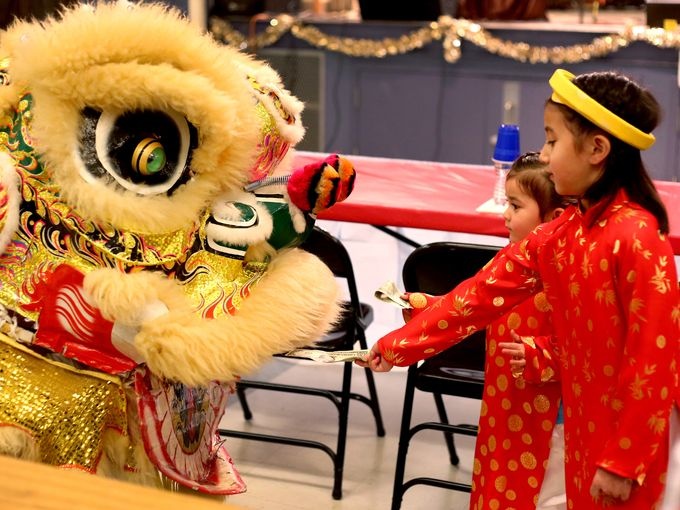 Hai bé Cousins Mylee Bell, 7 tuổi và  Jayda Sprague, 3, tuổi, tặng tiền cho những chú sư tử đang biểu diễn màn múa lân. 