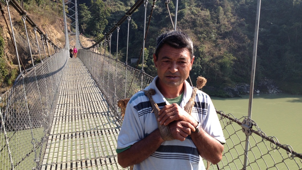 Người đàn ông này thường di chuyển qua cầu treo mỗi lần sang bờ bên kia để bán đậu.