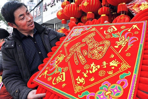 Một người dân tỉnh Chiết Giang, Trung Quốc, mua chữ và câu đối về trang trí trong nhà vào ngày Tết âm lịch 2015. Ảnh: AFP