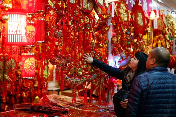 Một cặp vợ chồng ở Bắc Kinh đang chọn mua đồ trang trí trong nhà vào ngày Tết âm lịch. Ảnh: AFP