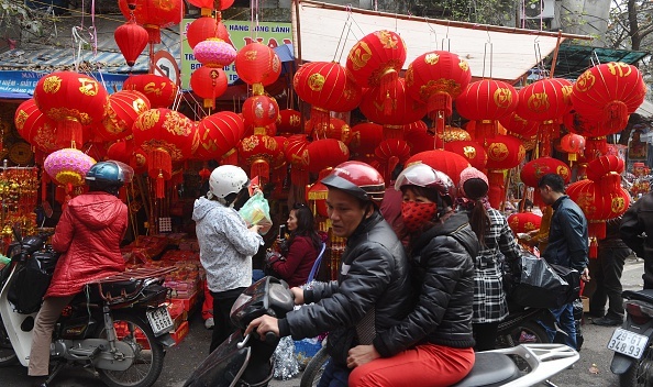Người dân hối hả mua vật dụng trang trí ngày Tết ở Phố Cổ tại Hà Nội. Ảnh: AFP