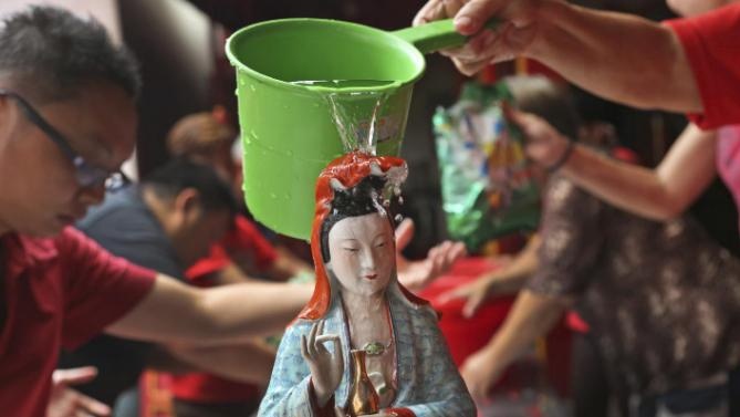 Người dân rửa tượng Phật Quan âm tại một ngôi chùa trong khu phố người Hoa ở thủ đô Jakarta, Indonesia. Ảnh: AP