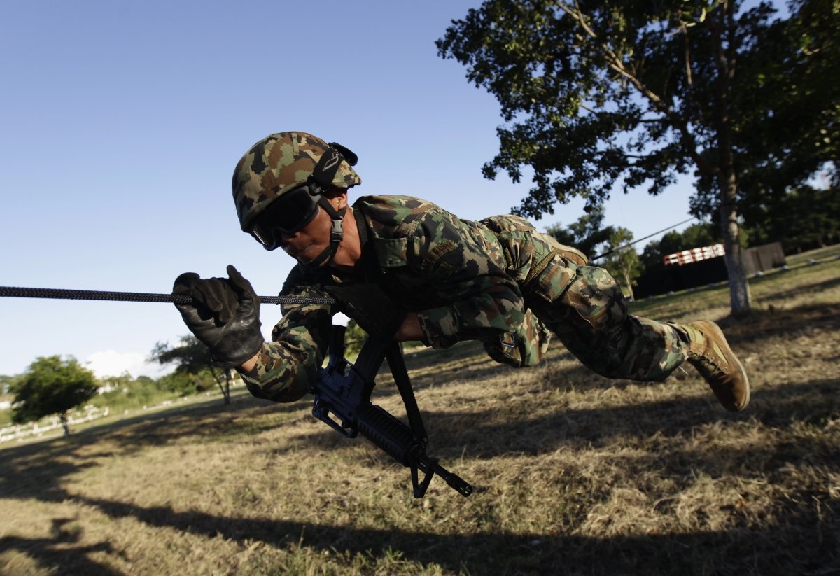 Một sĩ quan hải quân Mexico thực hiện bài tập bò trườn trên một sợi dây sắt tại căn cứ quân sự ở Chetumal, năm 2012.