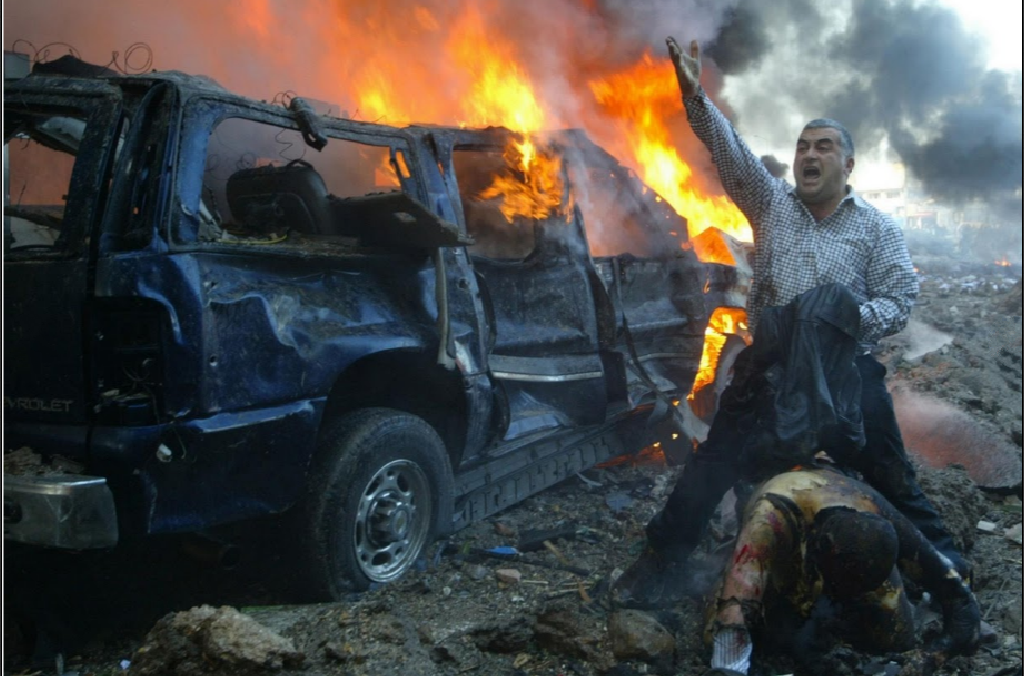 Một người đàn ông Lebanon hét to để tìm kiếm sự giúp đỡ sau khi thấy một người bị thương nặng tại khu vực gần nơi vụ đánh bom xe xảy ra tại Beirut. Vụ nổ đã khiến cựu Thủ tướng Lebanon Rafik al-Hariri và 8 người khác thiệt mạng. 