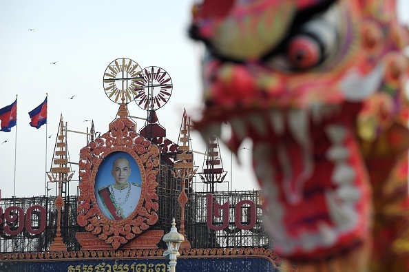 Một nghệ sĩ lân sư rồng biểu diễn ở quảng trường tại trước cung điện hoàng gia Campuchia, đằng sau là chân dung quốc vương Norodom Sihamoni vào ngày 30 âm lịch.