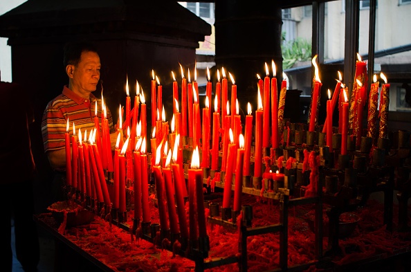 Một người đàn ông Philippines thắp nến tại một ngôi chùa Phật giáo tại Manila trong sáng mùng 1 Tết âm lịch. 