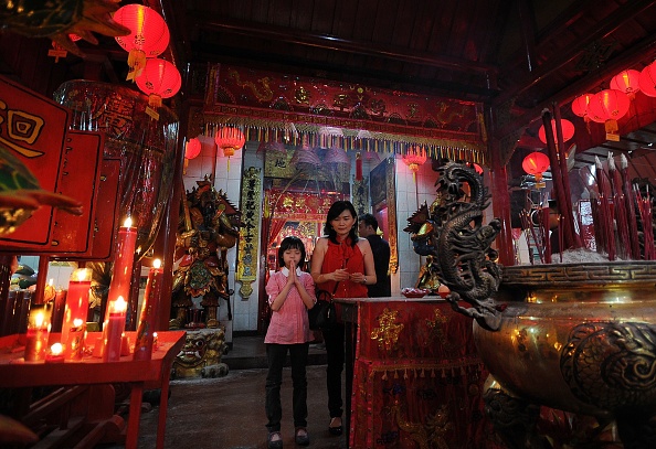 Một em nhỏ chắp tay và cầu nguyện trước Đức Phật tại chùa Hong San Ko Tee ở Surabaya, Indonesia. 