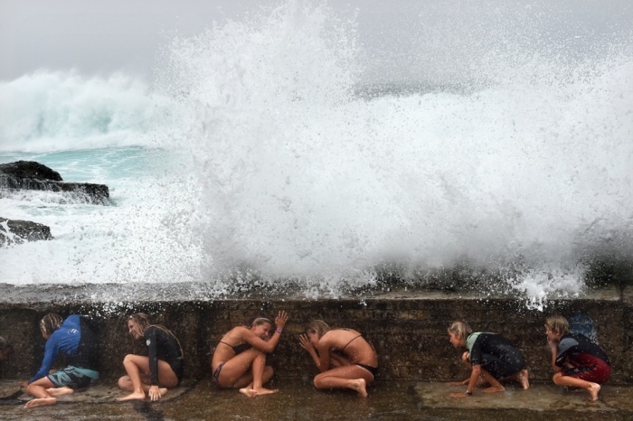 Các cô gái núp dưới một con đê của Bờ Biển Vàng khi sóng dâng cao do cơn bão nhiệt đới Marica đổ bộ vào đông bắc Australia hôm 20/2. 