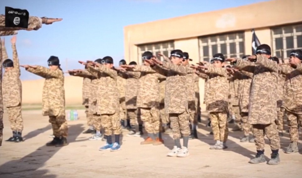 Những học viên nhí mặc đồng phục quân đội, vận khăn trùm màu đen, tham gia lớp học đào tạo chiến binh của IS. Daily Mail cho biết, học viên nhỏ nhất mới khoảng 5 tuổi.