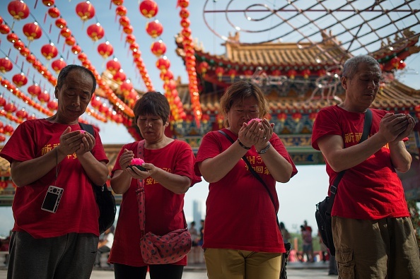 Gia đình của những hành khách người Trung Quốc trên chuyến bay MH370 cầu nguyện cho các nạn nhân ngày 1/3/2015, vài ngày trước khi phi cơ mất tích tròn 1 năm. Ảnh: AFP