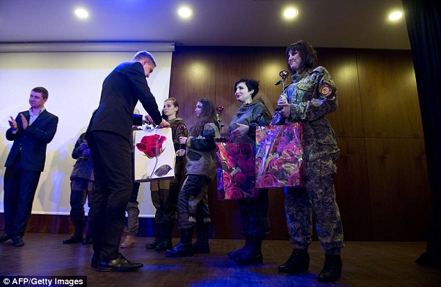 Sau màn trình diễn, đại diện chính quyền đã tặng hoa và quà cho các cô gái trong sự kiện chào mừng ngày Quốc tế phụ nữ. Ảnh: AFP