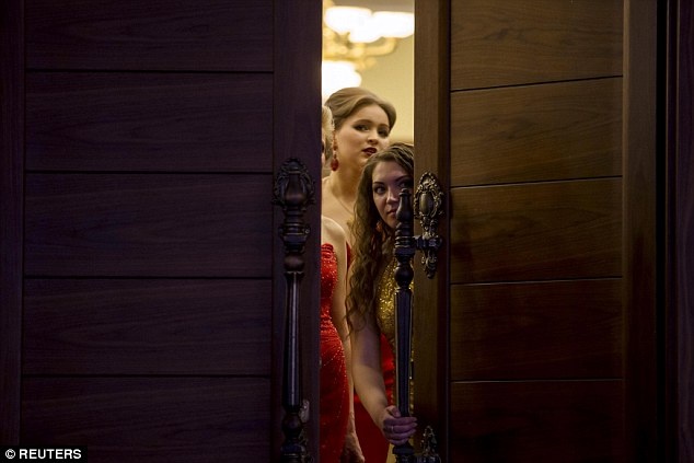 Một số phụ nữ lén nhìn qua cửa, chờ tới phần trình diễn của mình. Ảnh: Reuters