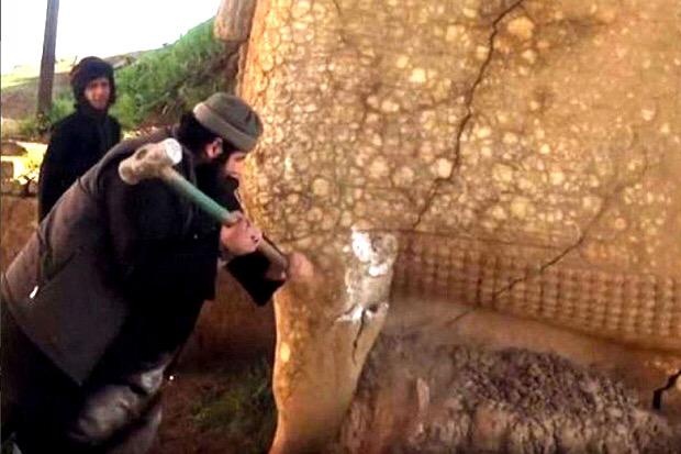 Phiến quân IS đập phá các di tích cổ ở Iraq. Ảnh: RT