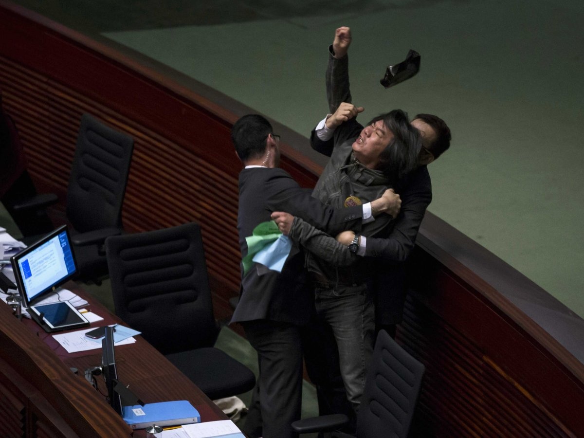 Nhà lập pháp ủng hộ đảng Dân chủ Hong Kong, ông Leung Kwok Hung, ném một vật về phía John Tsang, cục trưởng Cục Tài chính trong một cuộc họp. 