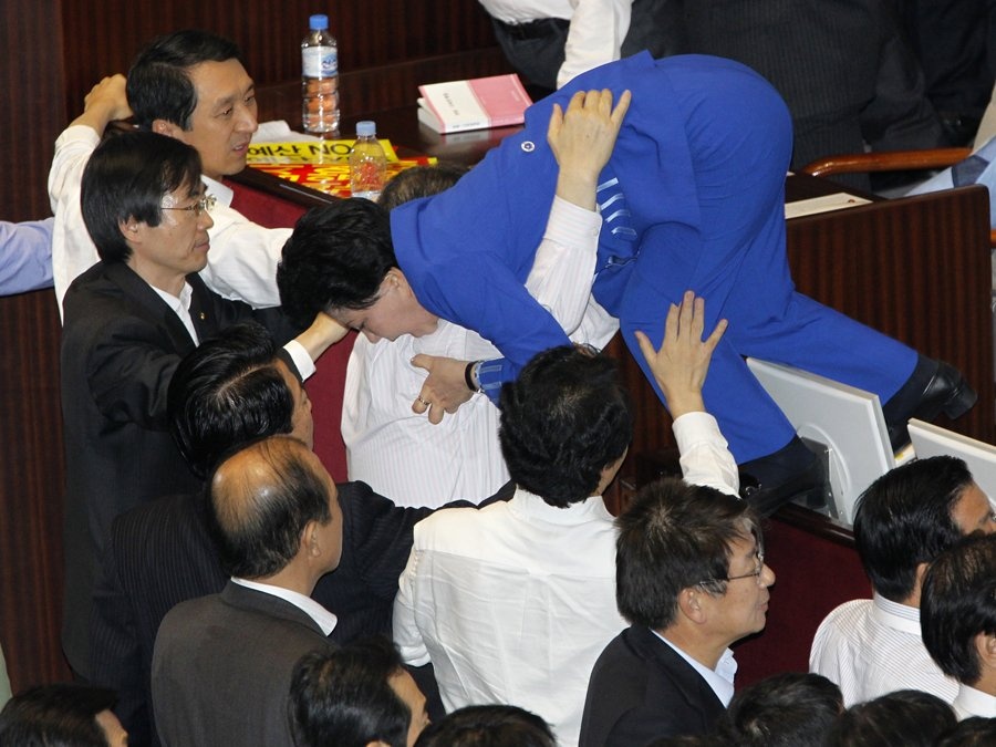 Một nữ nghị sĩ Hàn Quốc cố chạy khỏi đám đông đang tranh cãi về dự luật môi trường. 