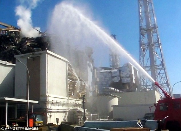 Công nhân phun nước làm mát lò phản ứng uranium ở nhà máy điện hạt nhân Fukushima. Thảm họa sóng thần khiến các lò phản ứng bị hư hại, gây nên thảm họa hạt nhân nghiêm trọng nhất ở Nhật Bản trong thời hiện đại. Ảnh: AFP