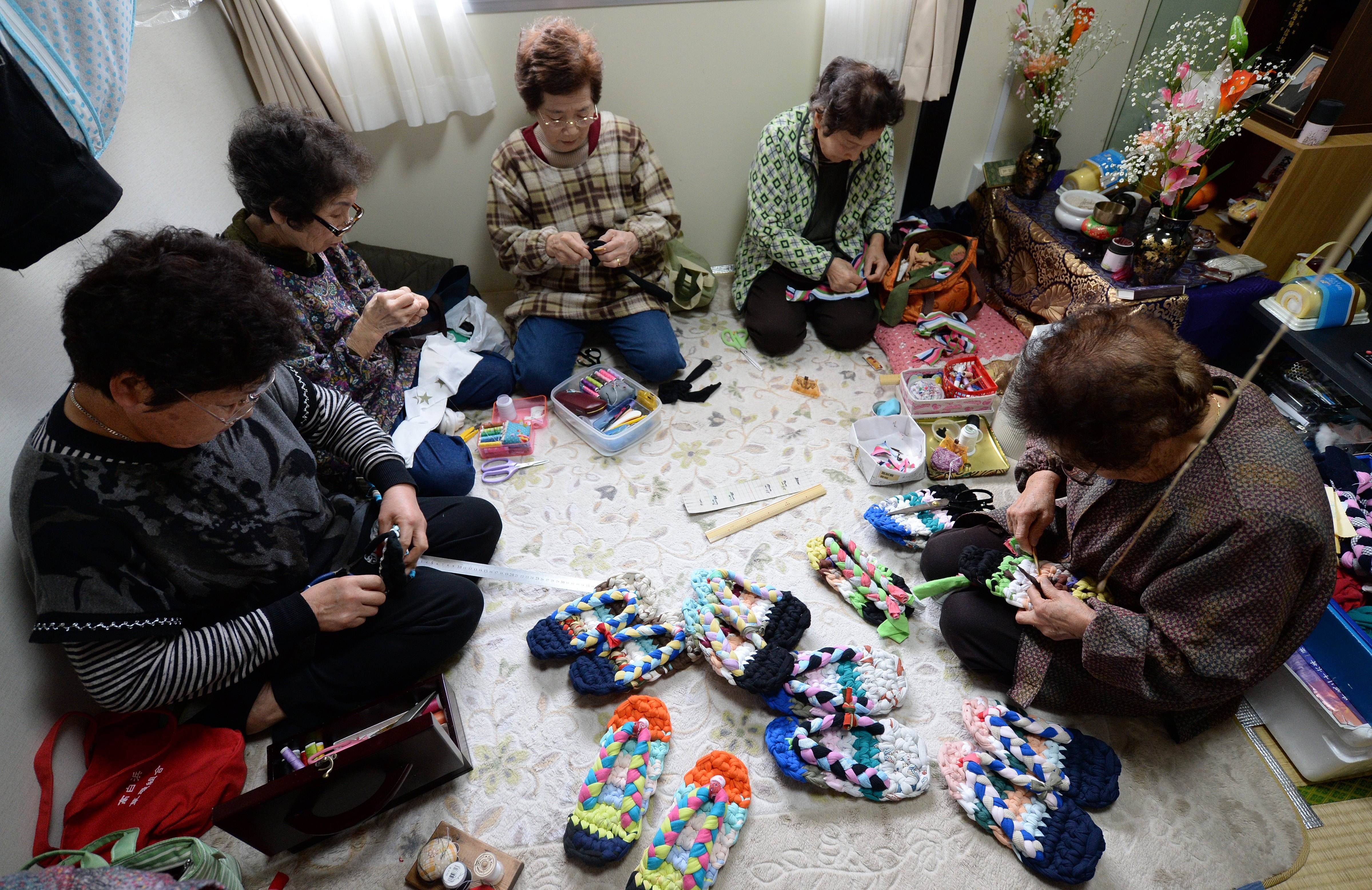 Những cụ bà ngồi làm giầy vải trong một căn phòng nhỏ ở khu nhà tạm thời dành cho người mất nhà sau thảm họa sóng thần năm 2011 ở tỉnh Miyagi. Ảnh: Japan Times