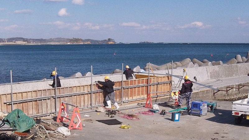 Công nhân đang xây một bức tường bê tông dọc bờ biển thành phố Kesennuma, tỉnh Miyagi, là một trong những vùng bị ảnh hưởng nặng nhất trong đợt thảm họa kép tháng 3/2011. Ảnh: NPR
