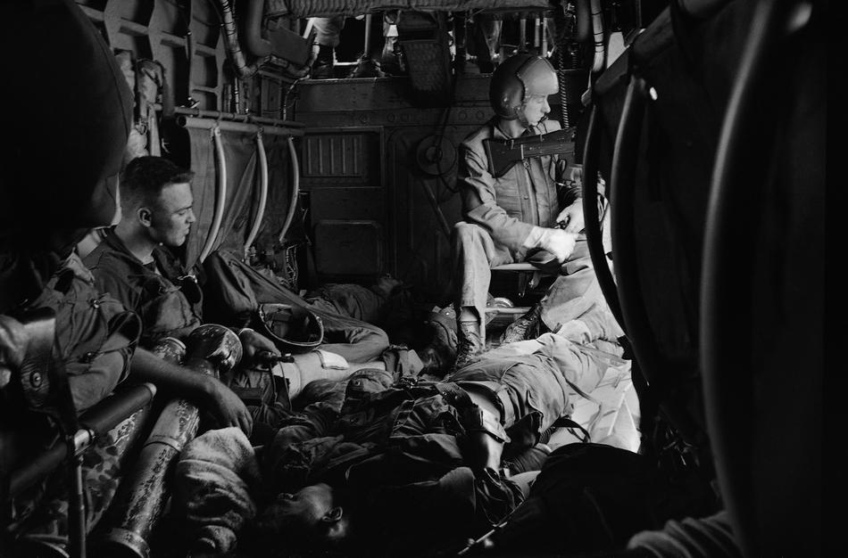 Lính thủy đánh bộ bị thương nằm trên sàn của trực thăng H34, ngày 19/8/1965 khi họ di tản từ vùng chiến trận ở bán đảo Vạn Tường 