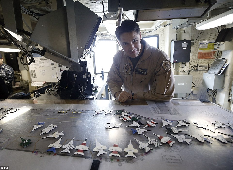 Hạm trưởng William Paxton trong phòng điều hành bay trên tàu USS Theodore Roosevelt. Tàu mang theo lượng lượng thực đủ để hoạt động trong 90 ngày, phục vụ 18.150 bữa ăn mỗi ngày.