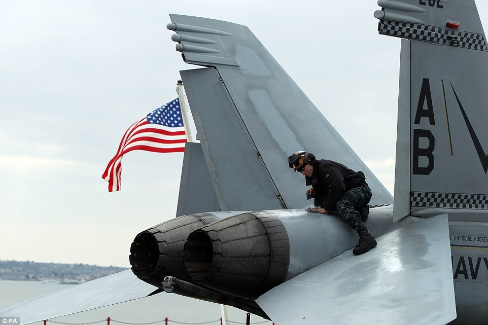 Một chuyên viên kỹ thuật của hải quân đang kiểm tra các máy bay trên tàu sân bay. Tham gia chiến dịch tiêu diệt IS cùng tàu USS Theodore Roosevelt là tàu khu trục HMS Duncan. Sứ mệnh quan trọng gần nhất của tàu sân bay này diễn ra năm 2002, kéo dài 159 ngày trên biển.
