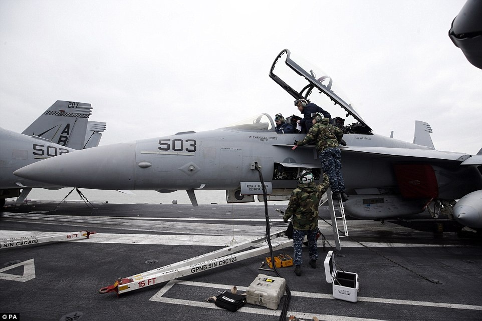 Các chuyên viên hải quân Mỹ đang kiểm tra những máy bay chiến đấu đáp trên tàu sân bay USS Theodore Roosevelt. 