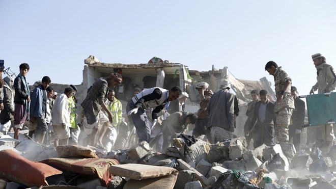 Người dân đào bới tìm kiếm những người sống sót sau vụ không kích gần sân bay Sanaa hôm 26/3.