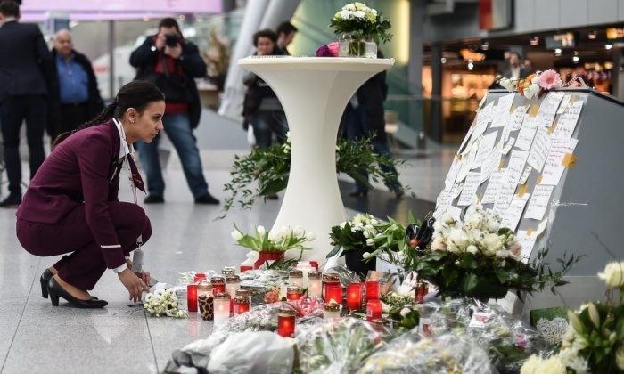 Một nhân viên hãng Germanwings đặt hoa tưởng niệm các nạn nhân ở sân bay Dusseldorf, Đức. Ảnh: EPA