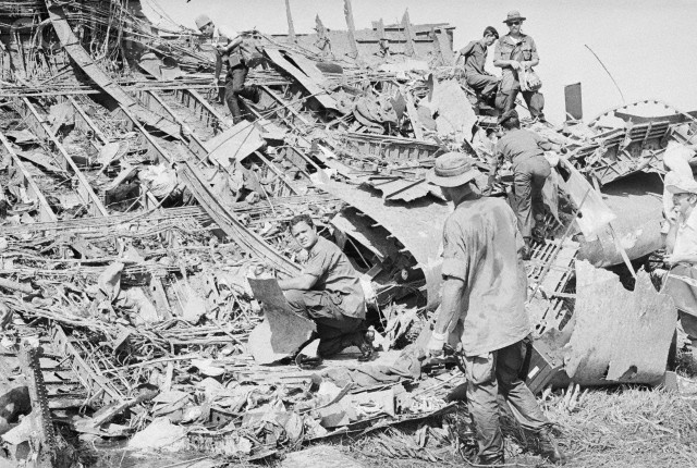 Các quan chức quân sự Mỹ tìm kiếm nạn nhân giữa những mảnh vỡ phi cơ tại hiện trường rơi của C5A gần sân bay Tân Sơn Nhất. 