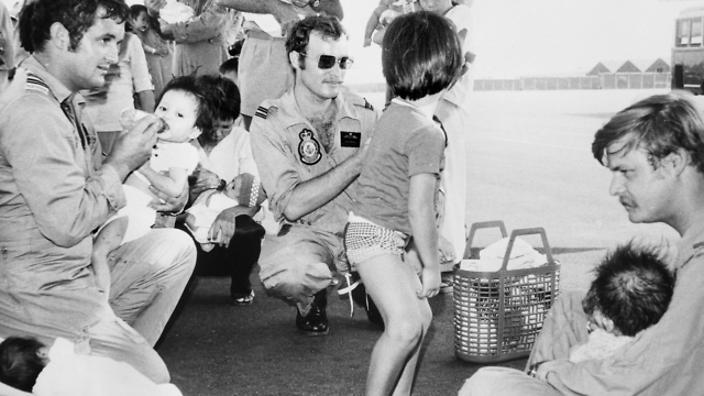 Lính Mỹ chăm sóc trẻ em Việt Nam tại sân bay trong chiến dịch Babylift. Ảnh: SBS