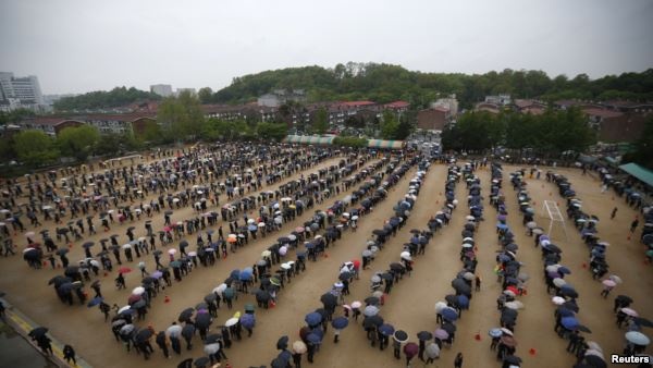 Những người đưa tiễn xếp hàng dài tỏ lòng thương tiếc các nạn nhân trong vụ đắm phà Sewol, gần một bàn thờ tưởng niệm tạm thời ở Ansan, Hàn Quốc, ngày 27/4/2014.