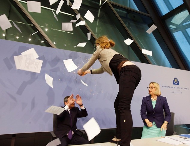 Khi ông Draghi, Chủ tịch Ngân hàng Trung ương châu Âu, đang phát biểu trong trụ sở của ngân hàng tại thành phố Frankfurt, Đức hôm 15/4, Josephine Witt, một người phụ nữ, bất ngờ nhảy lên bàn rồi ném hoa giấy về phía ông