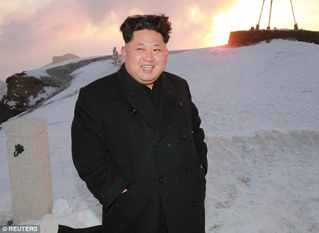 Trong trang phục áo khoác dài, giày da, nhà lãnh đạo 32 tuổi tươi cười khi đứng trên đỉnh