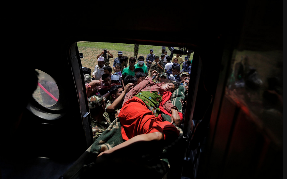 Binh sĩ Nepal chuyển người bị thương lên trực thăng. Ảnh: AP